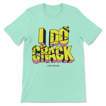 A mint green short-sleeve t-shirt with a bold graphic on the front reading 'I DO CRACK' in yellow 3D letters with pink shadows, and smaller text 'UNDER PRESSURE' below.