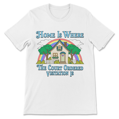 A white short-sleeve crewneck t-shirt with a colorful graphic print on the front. The graphic features a house, trees, a rainbow, and the text 'Home Is WHERE The Court Ordered Visitation IS' in blue lettering.