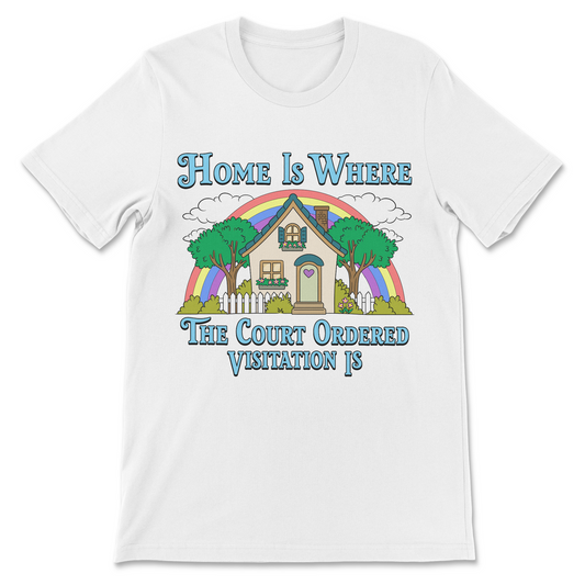 A white short-sleeve crewneck t-shirt with a colorful graphic print on the front. The graphic features a house, trees, a rainbow, and the text 'Home Is WHERE The Court Ordered Visitation IS' in blue lettering.