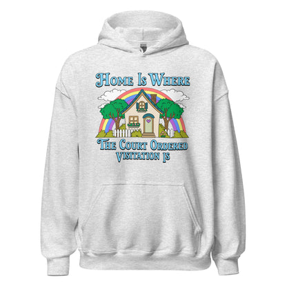A light heather gray pullover hoodie with a colorful graphic print on the chest. The graphic features a house, trees, a rainbow, and blue text that reads 'Home Is Where The Court Ordered Visitation Is'.