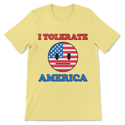 A pale yellow short-sleeve t-shirt with a graphic print on the front. The design features the text 'I TOLERATE' in red letters above a circular American flag-themed face with a blank expression, and the word 'AMERICA' in blue letters below.