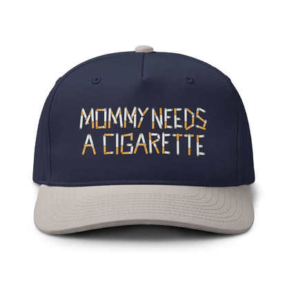 A navy blue baseball cap with a light gray visor and a gray top button, featuring the embroidered text 'MOMMY NEEDS A CIGARETTE' in white and orange on the front. The cap is shown against a plain white background.