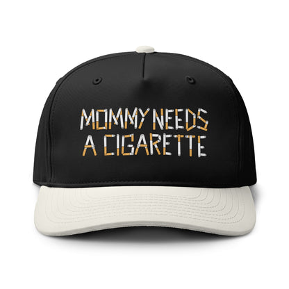 A black baseball cap with a white curved brim, featuring the embroidered text 'MOMMY NEEDS A CIGARETTE' in white and orange on the front. The cap is photographed on a clean white background.