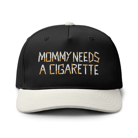 A black baseball cap with a white curved brim, featuring the embroidered text 'MOMMY NEEDS A CIGARETTE' in white and orange on the front. The cap is photographed on a clean white background.